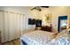 Bedroom with blue and white bedding, a ceiling fan, and a TV at 10745 Bardes Ct, Seminole, FL 33777