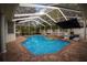 Screened pool and spa with brick pavers and lounge chairs at 10745 Bardes Ct, Seminole, FL 33777