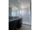 Bathroom with granite countertop, dark vanity, and shower at 10812 Fanning Springs Ct, Tampa, FL 33647