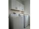 Laundry room with washer, dryer, and overhead cabinets at 10812 Fanning Springs Ct, Tampa, FL 33647