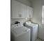 Bright laundry room with washer, dryer, and white cabinets at 10812 Fanning Springs Ct, Tampa, FL 33647