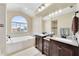 Elegant bathroom with double vanity, soaking tub, and large window at 11201 Lake Sassa Dr, Thonotosassa, FL 33592