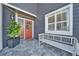 Red front door with a white bench and potted plant at 11201 Lake Sassa Dr, Thonotosassa, FL 33592