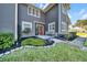 Landscaped front yard with gray house and red door at 11201 Lake Sassa Dr, Thonotosassa, FL 33592