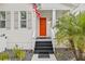 Bright orange front door with black steps and welcome mat at 11220 Moultrie Pl, Tampa, FL 33625