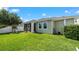 Backyard featuring a green lawn, playset, screened patio, and partial home view at 11540 Balintore Dr, Riverview, FL 33579