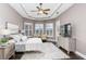 Main bedroom with TV, window seating, and dark wood floors at 11919 Royce Waterford Cir, Tampa, FL 33626