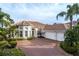 Stunning house exterior featuring a brick driveway and a three-car garage at 11919 Royce Waterford Cir, Tampa, FL 33626