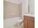 Bathroom with beige tile, a tub, toilet and wood vanity at 12119 Creek Preserve Dr, Riverview, FL 33579