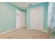 Bedroom with teal walls, carpet, and white closet doors at 12119 Creek Preserve Dr, Riverview, FL 33579