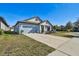 Newly built home with light blue exterior, landscaping, and a two-car garage at 12119 Creek Preserve Dr, Riverview, FL 33579