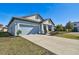 Newly built home with light blue exterior, landscaping, and a two-car garage at 12119 Creek Preserve Dr, Riverview, FL 33579