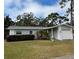 Gray house with white trim, nicely landscaped lawn, and attached garage at 12264 103Rd St, Largo, FL 33773