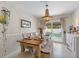 Farmhouse dining room with wooden table, chandelier, and pool view at 13472 Bellewood Ave, Seminole, FL 33776