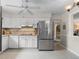 Clean kitchen featuring white cabinets, stainless steel fridge, and terrazzo floor at 13472 Bellewood Ave, Seminole, FL 33776