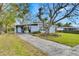 Ranch-style home with carport and mature landscaping at 1434 Longwood Loop, Tampa, FL 33619