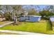 Single-story home with light blue exterior and a tree in the front yard at 1434 Longwood Loop, Tampa, FL 33619