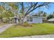 Light blue ranch home with a large tree in the front yard at 1434 Longwood Loop, Tampa, FL 33619