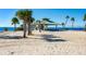 Sandy beach area with gazebo and palm trees at 17 Venetian Ct, Tarpon Springs, FL 34689