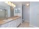 Bathroom with double sinks, white cabinets, and tiled floor at 17533 Stinchar Dr, Land O Lakes, FL 34638