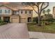 Tan two-story townhome with teal door, two-car garage, and paved driveway at 17533 Stinchar Dr, Land O Lakes, FL 34638