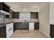 Kitchen with dark cabinets and white appliances at 18420 Burrell Rd, Odessa, FL 33556