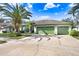 Single-story house with a three-car garage and a lush green lawn at 2005 Wexford Green Dr, Valrico, FL 33594