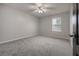 Bright bedroom with grey carpet, ceiling fan and window at 2291 Bolzano Ct, Land O Lakes, FL 34639