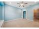 Blue bedroom with window seat, ceiling fan, and closet at 2648 Tanglewood Trl, Palm Harbor, FL 34685