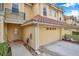 Tan townhome with a two-car garage and walkway to the entrance at 2648 Tanglewood Trl, Palm Harbor, FL 34685