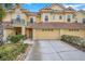 Tan townhome with two-car garage and neatly landscaped front at 2648 Tanglewood Trl, Palm Harbor, FL 34685