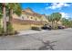 Row of tan townhomes with garages and tropical landscaping at 2648 Tanglewood Trl, Palm Harbor, FL 34685