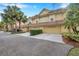 Tan townhome with a two-car garage and nicely landscaped front at 2648 Tanglewood Trl, Palm Harbor, FL 34685