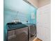 Laundry room with modern washer and dryer, and blue walls at 2648 Tanglewood Trl, Palm Harbor, FL 34685