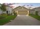 Tan two-story house with a two-car garage and landscaped lawn at 3304 Suncoast Plains Dr, Odessa, FL 33556