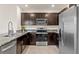 Modern kitchen with dark brown cabinets and granite countertops at 3304 Suncoast Plains Dr, Odessa, FL 33556