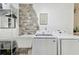 Laundry room with washer, dryer, sink and stone accent wall at 356 Grand Central Ave, Safety Harbor, FL 34695