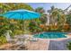 Inviting pool area with patio furniture, umbrella, and lush landscaping at 400 22Nd Ne Ave, St Petersburg, FL 33704