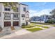 White three-story home with brown accents, two-car garage, and a front yard at 418 S Albany Ave, Tampa, FL 33606