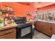 View of kitchen with black stove, wood cabinets and a well-stocked spice rack at 4308 Craftsbury Dr, New Port Richey, FL 34652