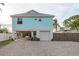 Two-story teal home with a white garage door and gravel driveway at 4536 Heavens Way, New Port Richey, FL 34652