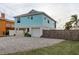 Two-story teal home with a white garage door and gravel driveway at 4536 Heavens Way, New Port Richey, FL 34652