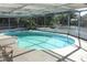 Kidney-shaped pool with screened enclosure at 5528 Berlin Dr, Port Richey, FL 34668