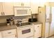 Kitchen boasts white cabinets, granite counters, microwave, and stove at 6158 Palma Del Mar S Blvd # 116, St Petersburg, FL 33715