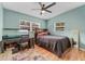 Bedroom with a queen bed, a built-in desk, and wood flooring at 6405 Julie St, Tampa, FL 33610