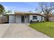 Updated home exterior with gray siding, a new driveway and landscaping at 6405 Julie St, Tampa, FL 33610