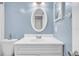 Updated bathroom with white vanity and oval mirror at 6960 20Th N Ave # 307, St Petersburg, FL 33710