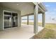 Covered back patio with sliding glass doors leading to the house at 7878 Greenway Ave, Wesley Chapel, FL 33544