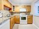 Well-equipped kitchen with wood cabinets and granite countertops at 7930 Sun Island S Dr # 305, South Pasadena, FL 33707