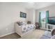 Bedroom with daybed, television, and window with teal curtains at 8332 Enclave Way # 101, Sarasota, FL 34243